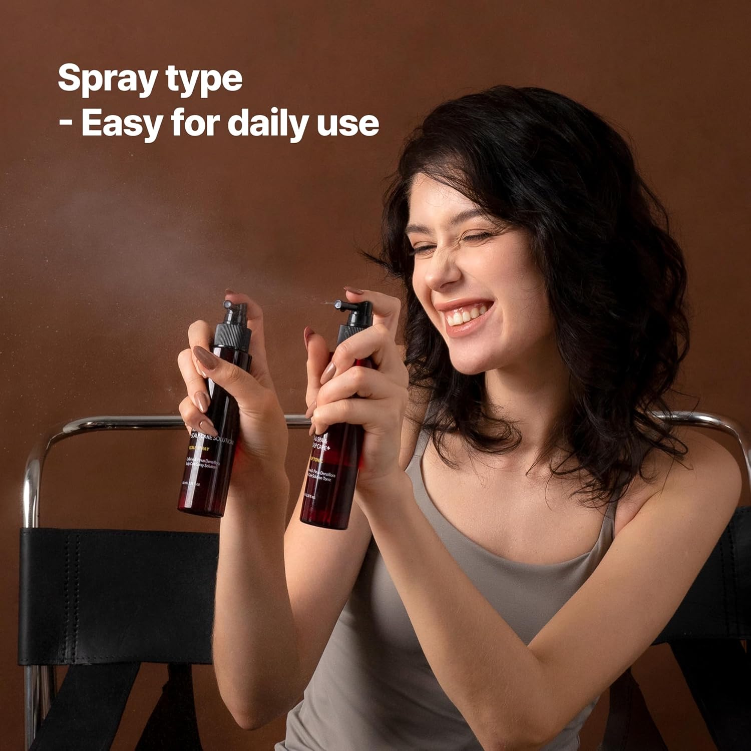 Woman holding two Kundal spray bottles with a brown background and text 'Spray type - Easy for daily use'.