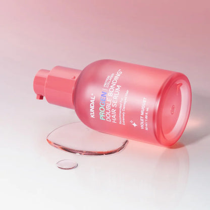Pink hair serum bottle with droplet on a light pink background