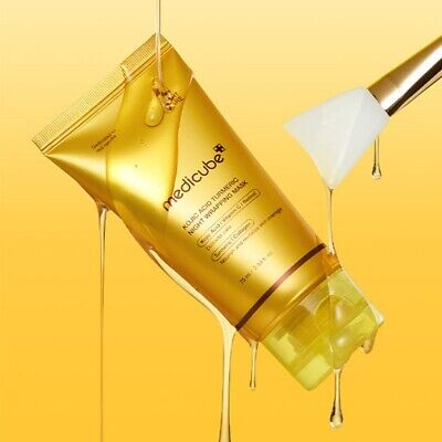 Gold tube of Medicube product with a white applicator on a yellow background
